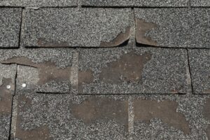 Aging roof with broken asphalt shingles